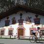 In bici di passaggio di fronte a una vecchia casa dipinta a Leutasch (foto Tirol Werbung)